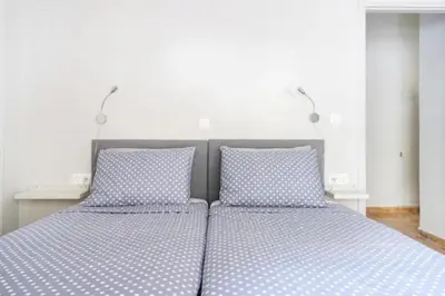 a bedroom with two twin beds with blue pillows at Flisvos Marina refurbished apartment in Athens