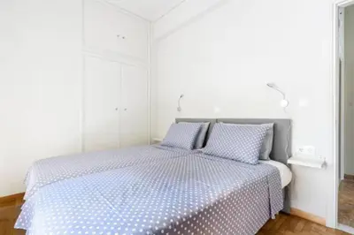 a bedroom with a bed with blue and white sheets at Flisvos Marina refurbished apartment in Athens