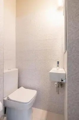 a white bathroom with a toilet and a sink at Flisvos Marina refurbished apartment in Athens