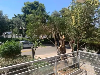 a fence in front of a parking lot with a car at Flisvos Marina refurbished apartment in Athens