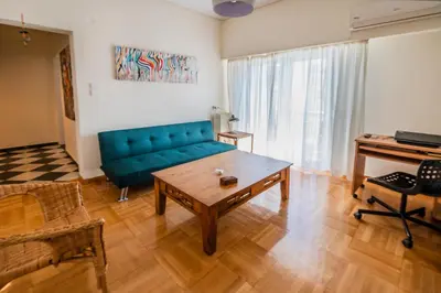 a living room with a blue couch and a piano at 5th Floor Boho Quircky in Athens