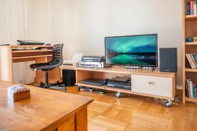 a living room with a television on a wooden entertainment center at 5th Floor Boho Quircky in Athens