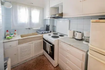 a kitchen with white cabinets and a stove top oven at 5th Floor Boho Quircky in Athens
