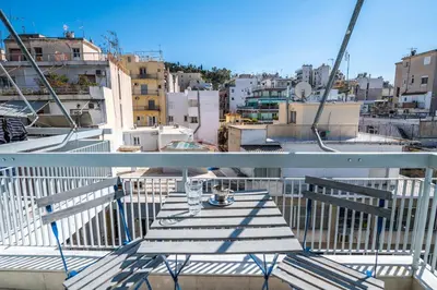 a table on a balcony with a view of a city at 5th Floor Boho Quircky in Athens