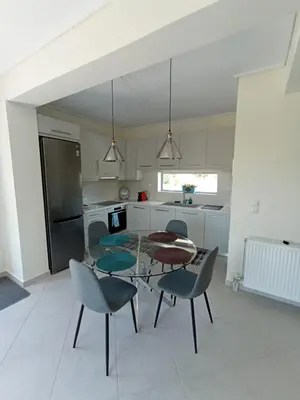 a kitchen with a glass table and chairs in a room at Andi's Studio Porto Rafti in Porto Rafti