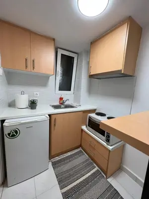 a small kitchen with white appliances and wooden cabinets at Your studio Athens in Athens