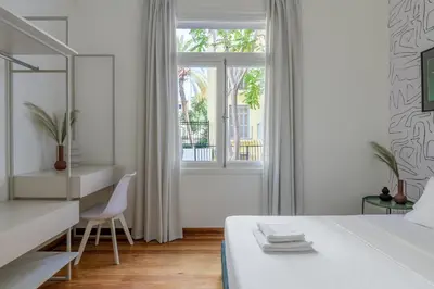 a white bedroom with a bed and a desk and a window at 3bdr Modern Design & Bright Interiors in Plaka in Athens