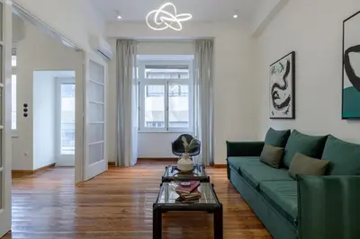 a living room with a green couch and a table at 3bdr Modern Design & Bright Interiors in Plaka in Athens
