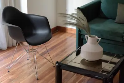 a black chair and a vase on a glass table at 3bdr Modern Design & Bright Interiors in Plaka in Athens