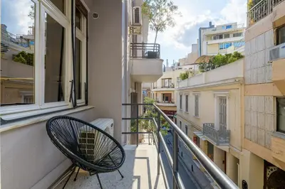 a balcony with a chair sitting on a balcony at 3bdr Modern Design & Bright Interiors in Plaka in Athens