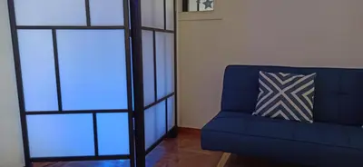 a blue couch in a living room with a pillow at 2 Bed Flat - Sleeps 5 - Parking - Wifi in Athens