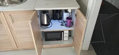 a kitchen counter with a cupboard with a microwave at 2 Bed Flat - Sleeps 5 - Parking - Wifi in Athens