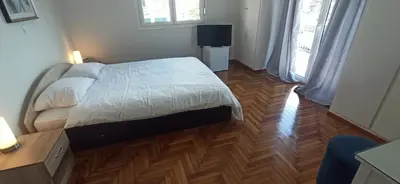 a bedroom with a bed and a wooden floor at 2 Bed Flat - Sleeps 5 - Parking - Wifi in Athens