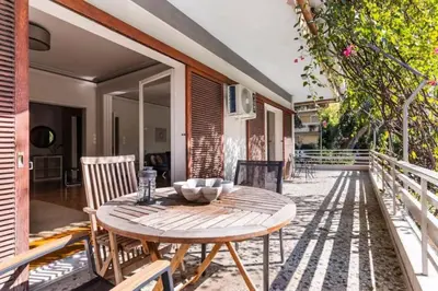 a wooden table and chairs on a patio at Spacious renovated flat in the Athens Riviera in Athens