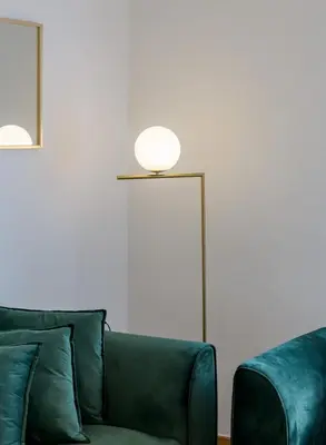 a living room with a green couch and a lamp at Lush Emerald apt steps from Acropolis & Plaka! in Athens
