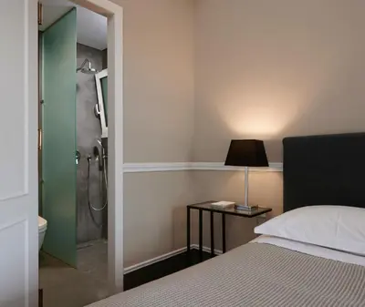 a bedroom with a shower and a bed and a lamp at Varaba Country House in Markopoulo