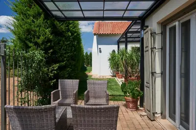 a group of chairs sitting on a patio at Varaba Country House in Markopoulo
