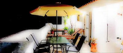 a table and chairs with an umbrella on a patio at Villa Hermes in Vouliagmeni