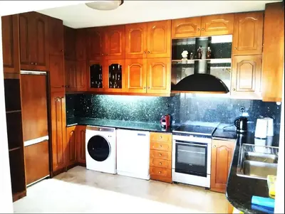 a kitchen with wooden cabinets and a white dishwasher at Villa Hermes in Vouliagmeni