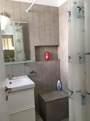 a bathroom with a sink and a shower with a mirror at Saronida beach apartments kids and pets friendly in Saronida