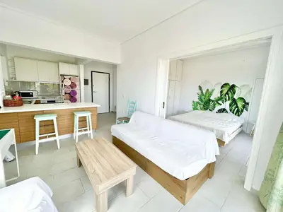 a large room with two beds and a kitchen at Saronida beach apartments kids and pets friendly in Saronida