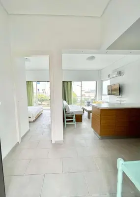 a kitchen and living room with white walls and tile floors at Saronida beach apartments kids and pets friendly in Saronida