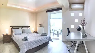 a bedroom with a bed and a desk and a window at A7 Beauty Vouliagmeni Apt in a unique Spot in Athens