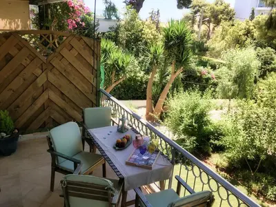 a balcony with a table and chairs and a fence at A7 Beauty Vouliagmeni Apt in a unique Spot in Athens