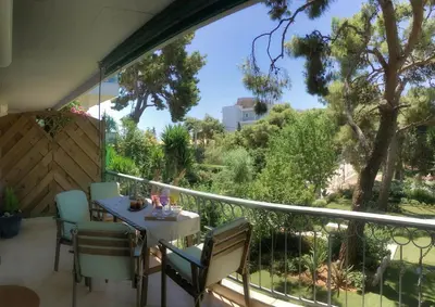 a balcony with a table and chairs and trees at A7 Beauty Vouliagmeni Apt in a unique Spot in Athens