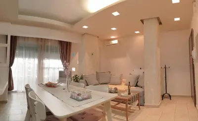 a living room with a white table and a couch at A7 Beauty Vouliagmeni Apt in a unique Spot in Athens
