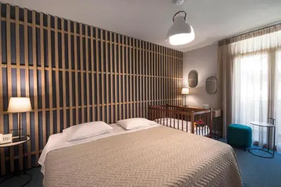 a bedroom with a bed and a wooden wall at Marina Alimos Hotel Apartments in Athens