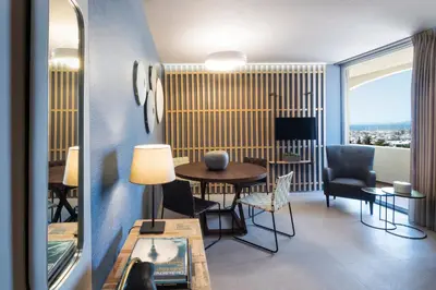 a living room with a table and chairs and a window at Marina Alimos Hotel Apartments in Athens