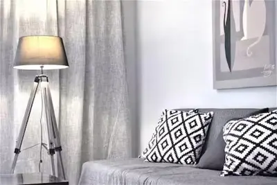 a lamp sitting next to a couch next to a window at Bright & Cozy 1BR in Athens city center in Athens