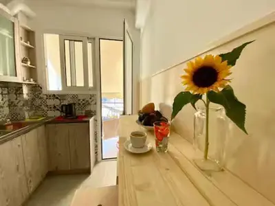 a sunflower in a vase on a table in a kitchen at Bright & Cozy 1BR in Athens city center in Athens