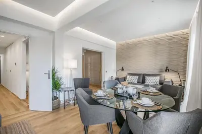 a dining room and living room with a table and chairs at Modern flat in the grounds of Acropolis Monuments -Armonia- in Athens