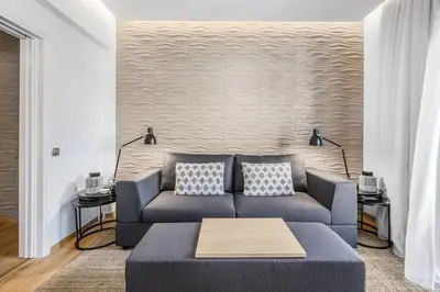 a living room with a blue couch with pillows at Modern flat in the grounds of Acropolis Monuments -Armonia- in Athens