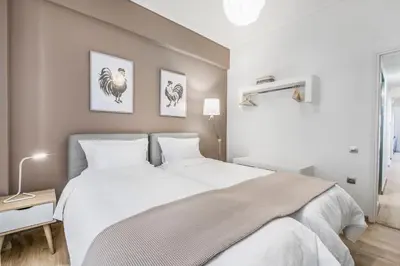 a bedroom with a large bed with white sheets at Modern flat in the grounds of Acropolis Monuments -Armonia- in Athens