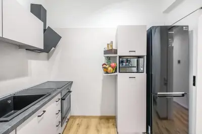 a white kitchen with a refrigerator and a sink at Modern flat in the grounds of Acropolis Monuments -Armonia- in Athens