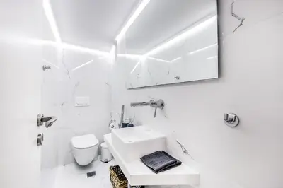 a white bathroom with a sink and a toilet at Modern flat in the grounds of Acropolis Monuments -Armonia- in Athens