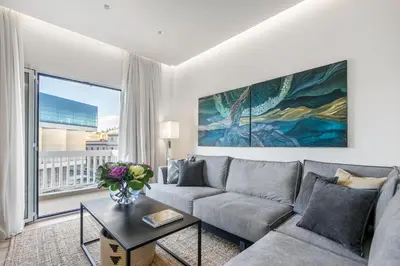 a living room with a couch and a large window at Modern flat in the grounds of Acropolis Monuments -Armonia- in Athens