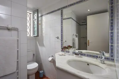 a bathroom with a sink and a toilet and a mirror at Muazzo Plaka Homes, Upper Home with Balcony & Ground Home No Balcony, by ThinkVilla in Athens