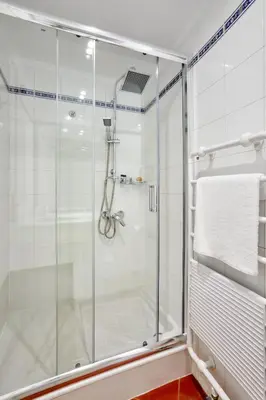 a shower with a glass door in a bathroom at Muazzo Plaka Homes, Upper Home with Balcony & Ground Home No Balcony, by ThinkVilla in Athens