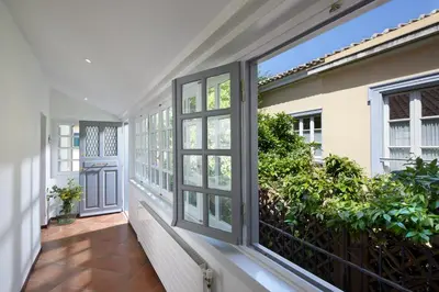 an empty hallway with windows and a door at Muazzo Plaka Homes, Upper Home with Balcony & Ground Home No Balcony, by ThinkVilla in Athens