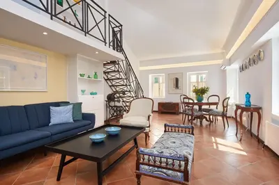 a living room with a blue couch and a table at Muazzo Plaka Homes, Upper Home with Balcony & Ground Home No Balcony, by ThinkVilla in Athens