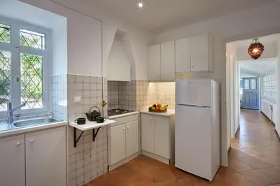 a kitchen with white cabinets and a white refrigerator at Muazzo Plaka Homes, Upper Home with Balcony & Ground Home No Balcony, by ThinkVilla in Athens