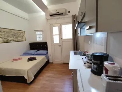 a small room with a bed and a kitchen at PURE URBAN PREMIUM METRO AGIOS NIKOLAOS in Athens