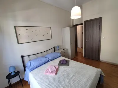 a bedroom with a bed with blue pillows and a table at PURE URBAN PREMIUM METRO AGIOS NIKOLAOS in Athens