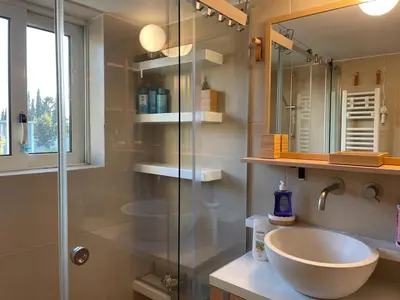 a bathroom with a sink and a glass shower at Nest in Mets in Athens