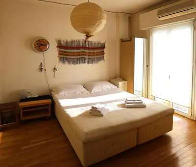 a bedroom with a large bed and a chandelier at Nest in Mets in Athens