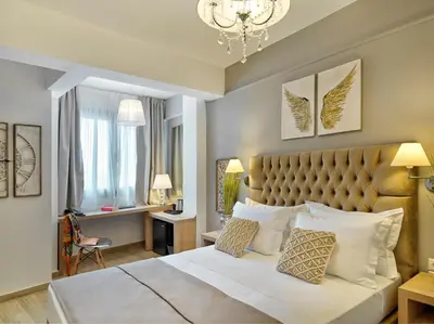 a bedroom with a large bed and a chandelier at Acropolis City Life BH in Athens